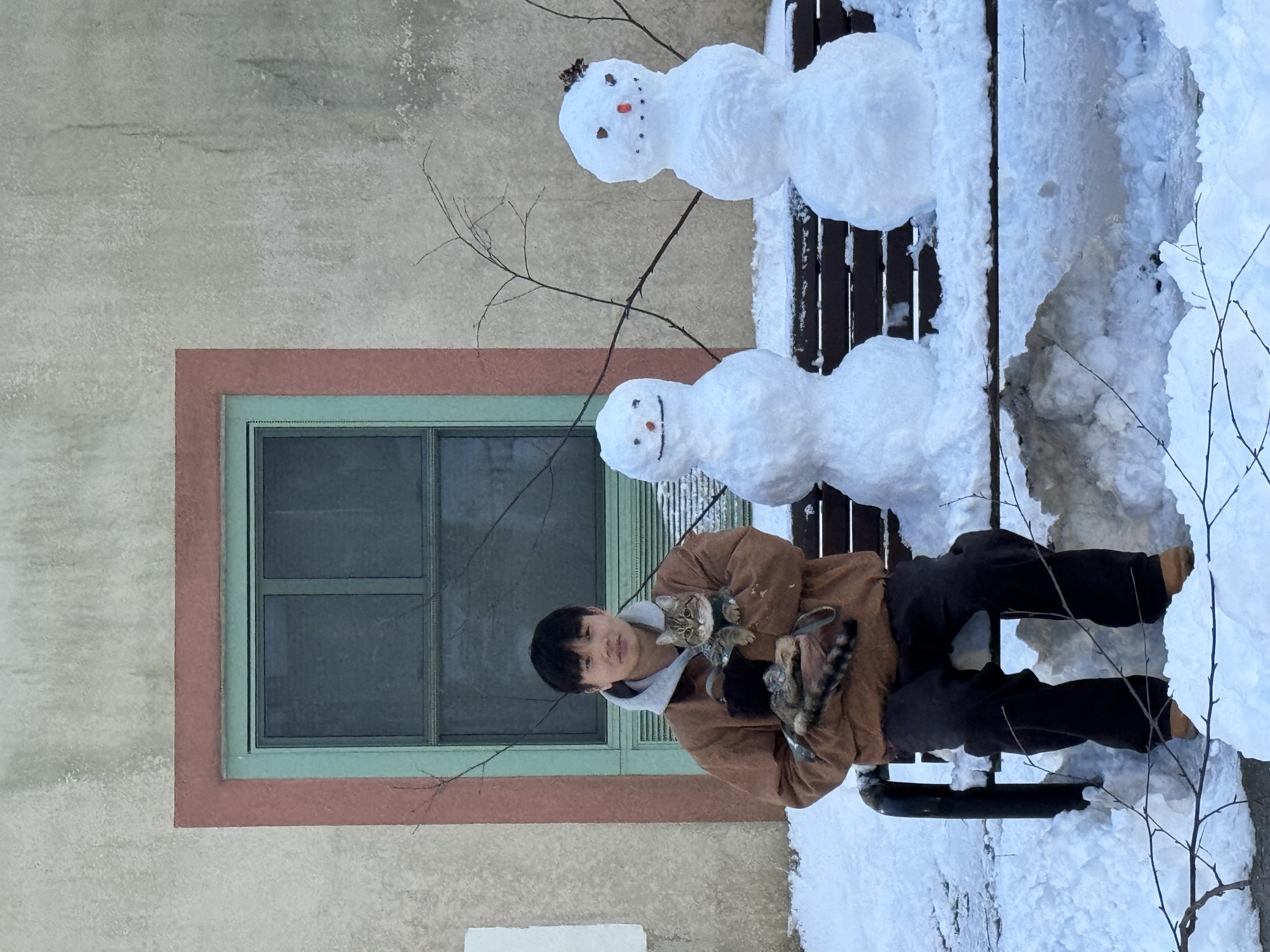 A cat, two snowmen, and one cold afternoon.
