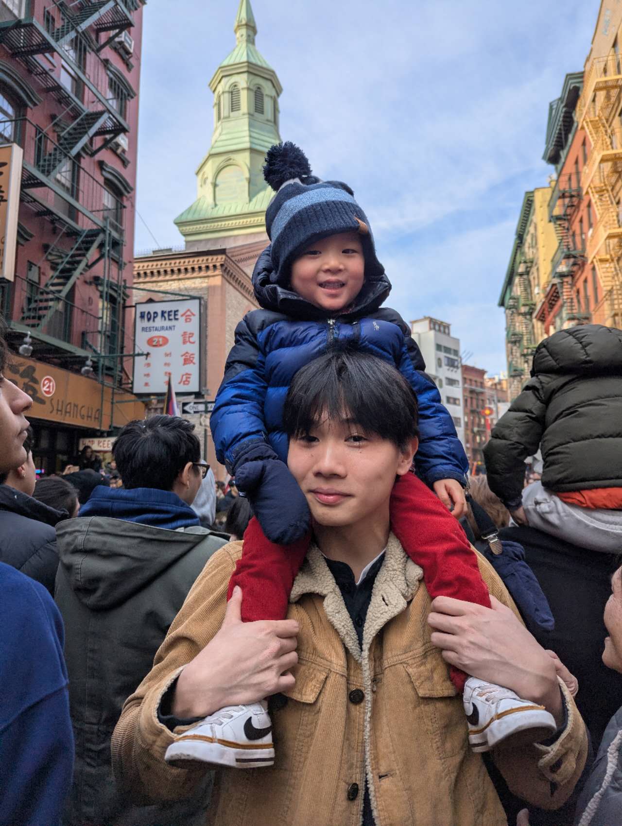 His cousin, riding shoulders through Chinatown.